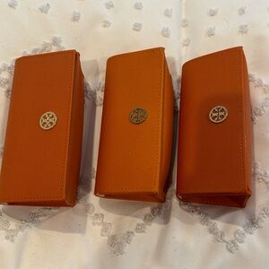 Three orange Tory Burch, sunglass cases
